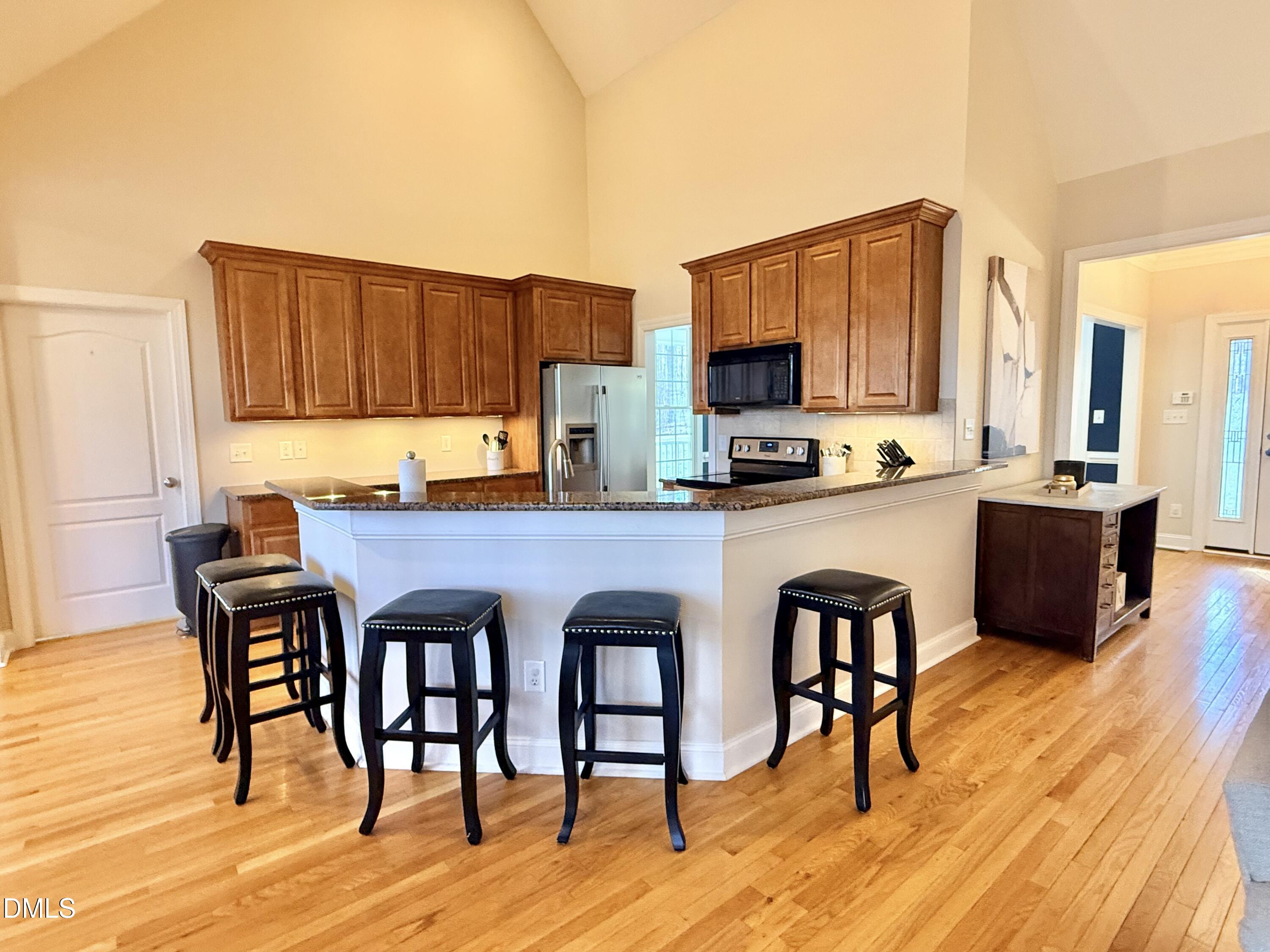 199 Oakwood Lane Roxboro, NC 27574 - Photo 12 of 82 a kitchen with stainless steel appliances granite countertop a stove top oven a sink a dining table and chairs with wooden floor