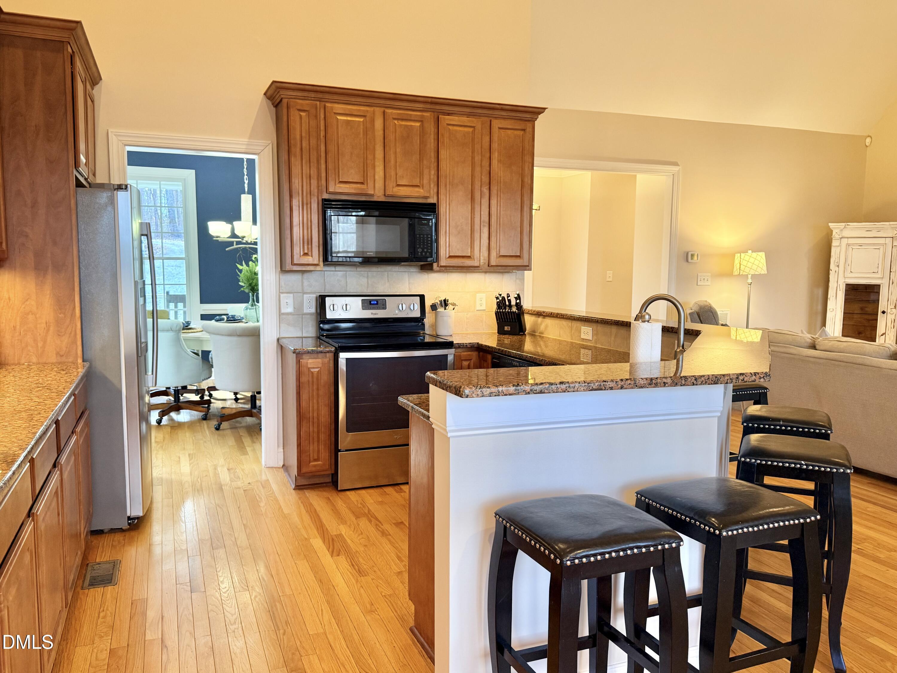 199 Oakwood Lane Roxboro, NC 27574 - Photo 15 of 82 a kitchen with stainless steel appliances a stove a sink cabinets and a dining table