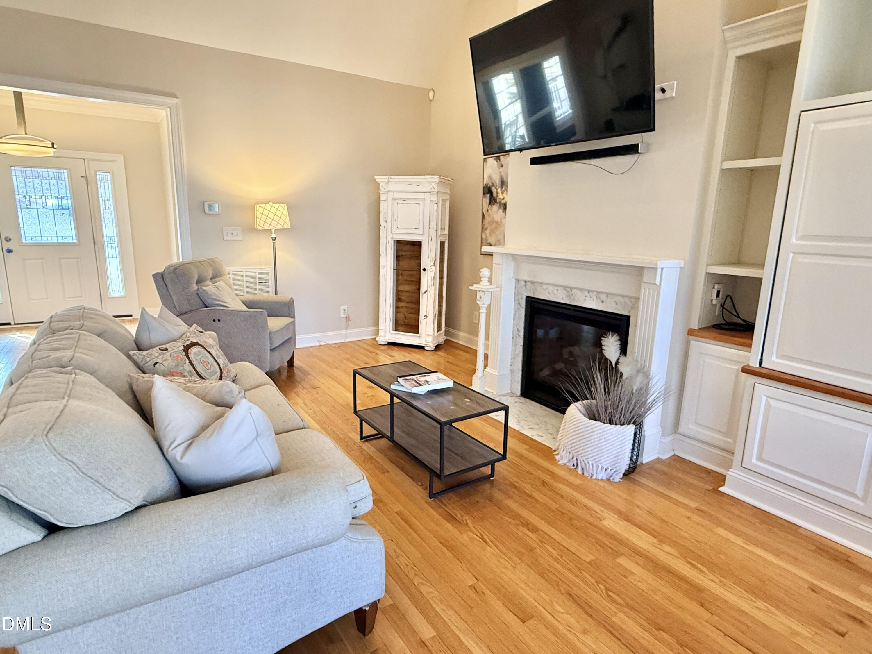 199 Oakwood Lane Roxboro, NC 27574 - Photo 7 of 82 a living room with furniture a flat screen tv and a fireplace