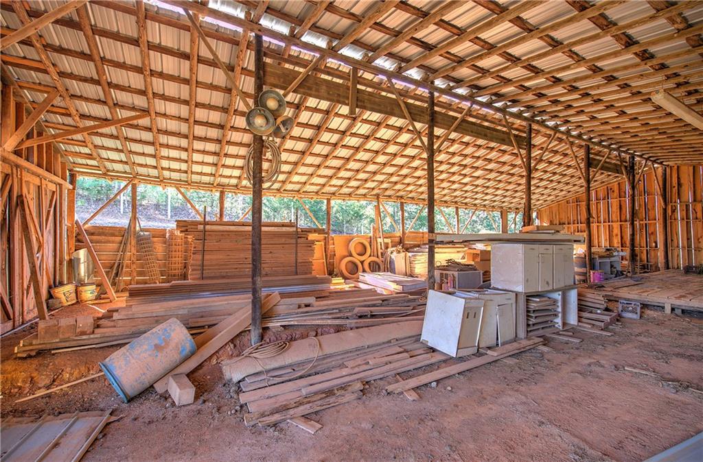 798 Mt Pleasant Road Rydal, GA 30171 - Photo 11 of 31 a view of a patio with couches and chairs under an umbrella with large trees