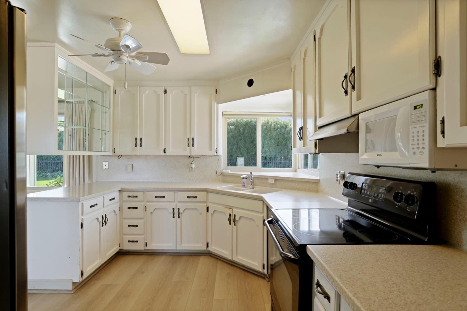2465 Vernalis Road Tracy, CA 95304 - Photo 8 of 55 a kitchen with stainless steel appliances a stove a sink cabinets and a window