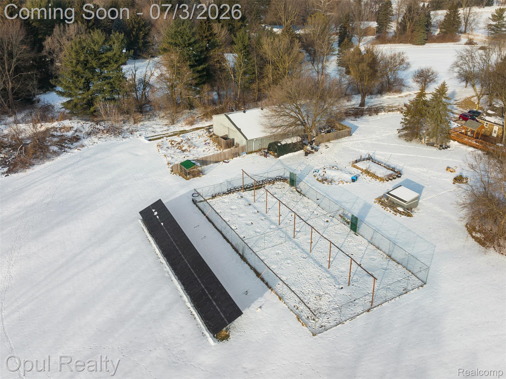 8855 Gross Road Dexter, MI 48130 - Photo 17 of 53 Expansive property featuring a large fenced enclosure, an additional outbuilding with a dark shingle roof, and multiple garden beds