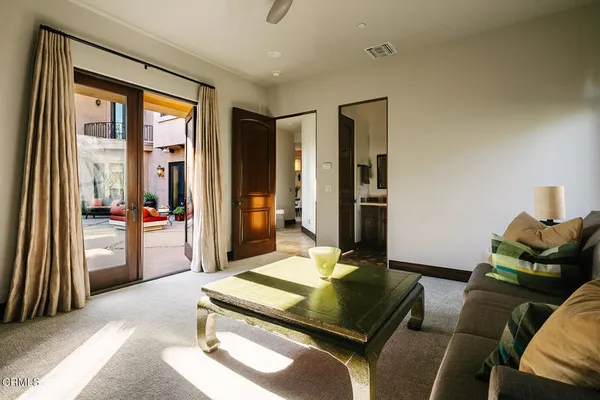a view of a hallway with wooden floor and a living room
