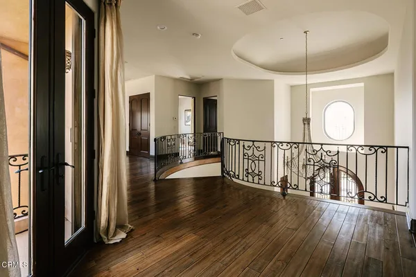 a bedroom with a bed and a large mirror next to a window