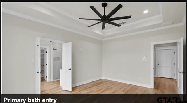 a view of a hallway with a chandelier fan and wooden floor
