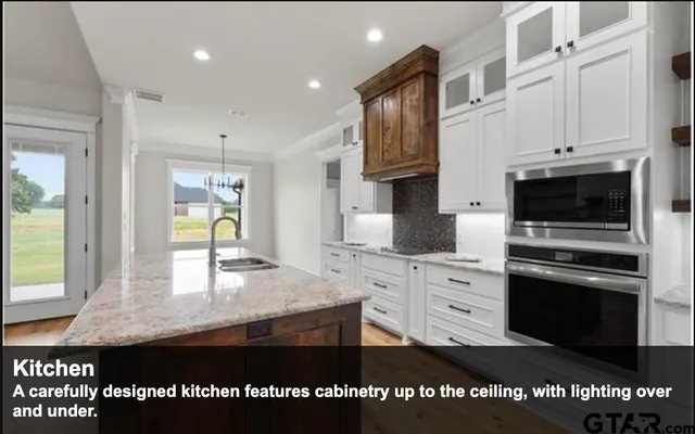 a kitchen with stainless steel appliances granite countertop a stove a sink and a microwave