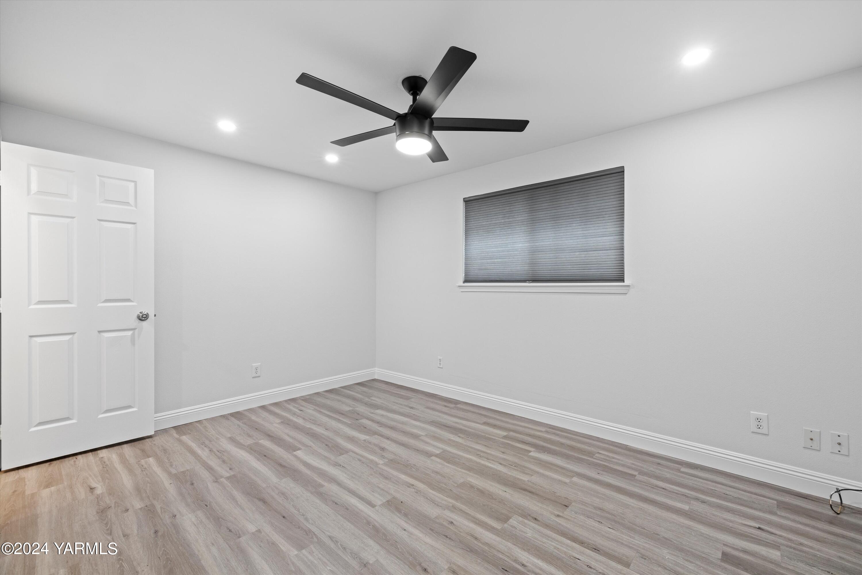 1511 Progressive Road Wapato, WA 98951 - Photo 11 of 36 an empty room with wooden floor ceiling fan and windows