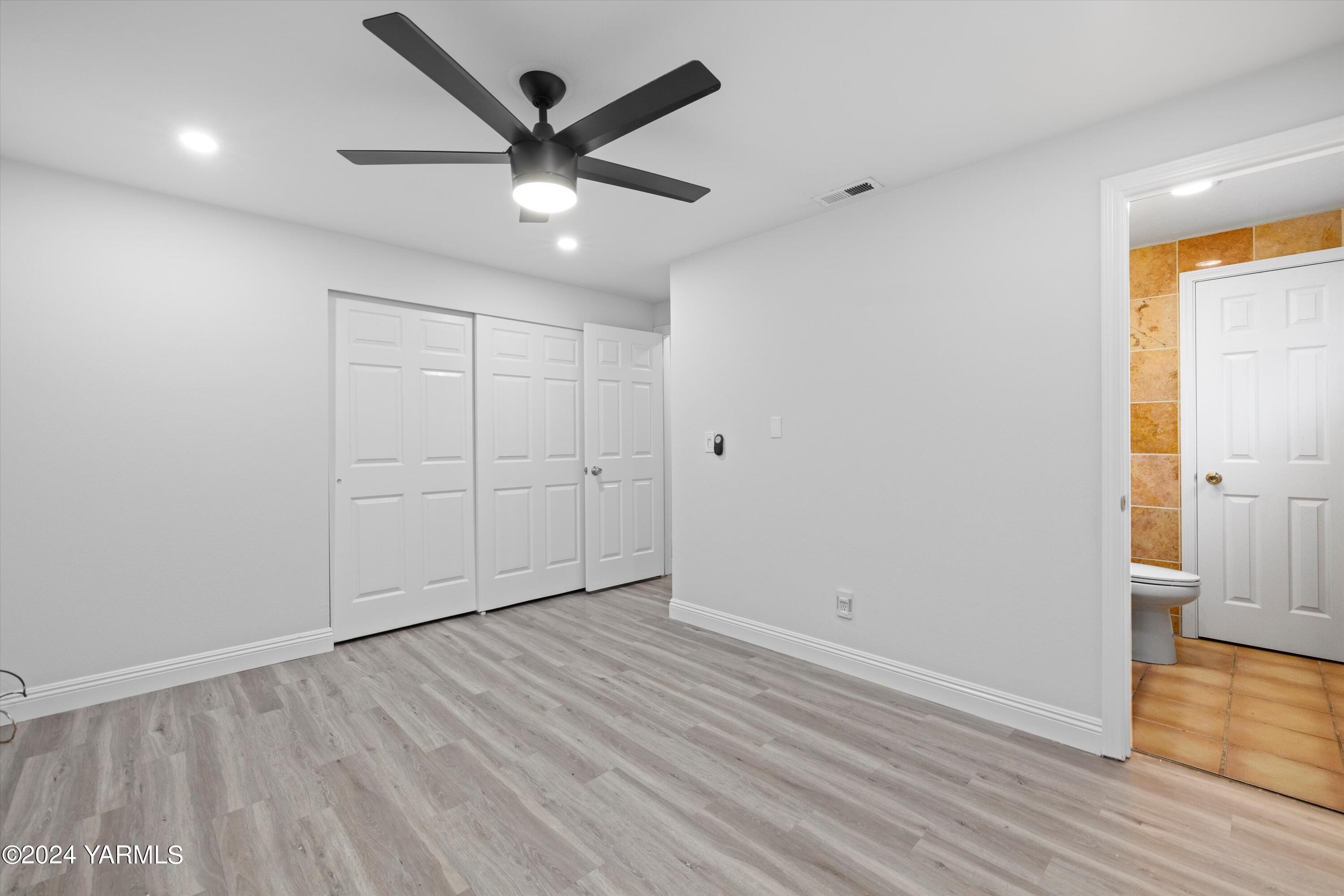 1511 Progressive Road Wapato, WA 98951 - Photo 15 of 36 an empty room with wooden floor and a ceiling fan