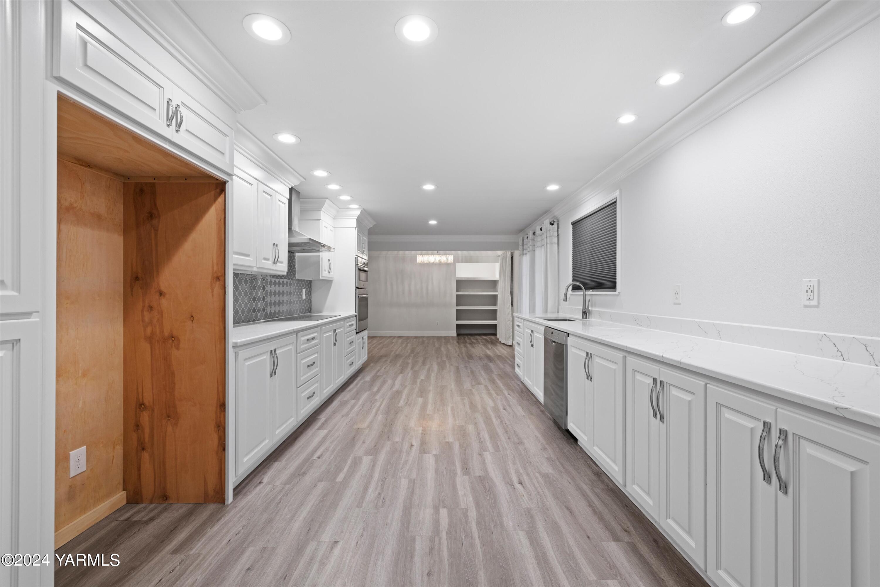 1511 Progressive Road Wapato, WA 98951 - Photo 24 of 36 a large kitchen with a center island wooden floor stainless steel appliances and cabinets