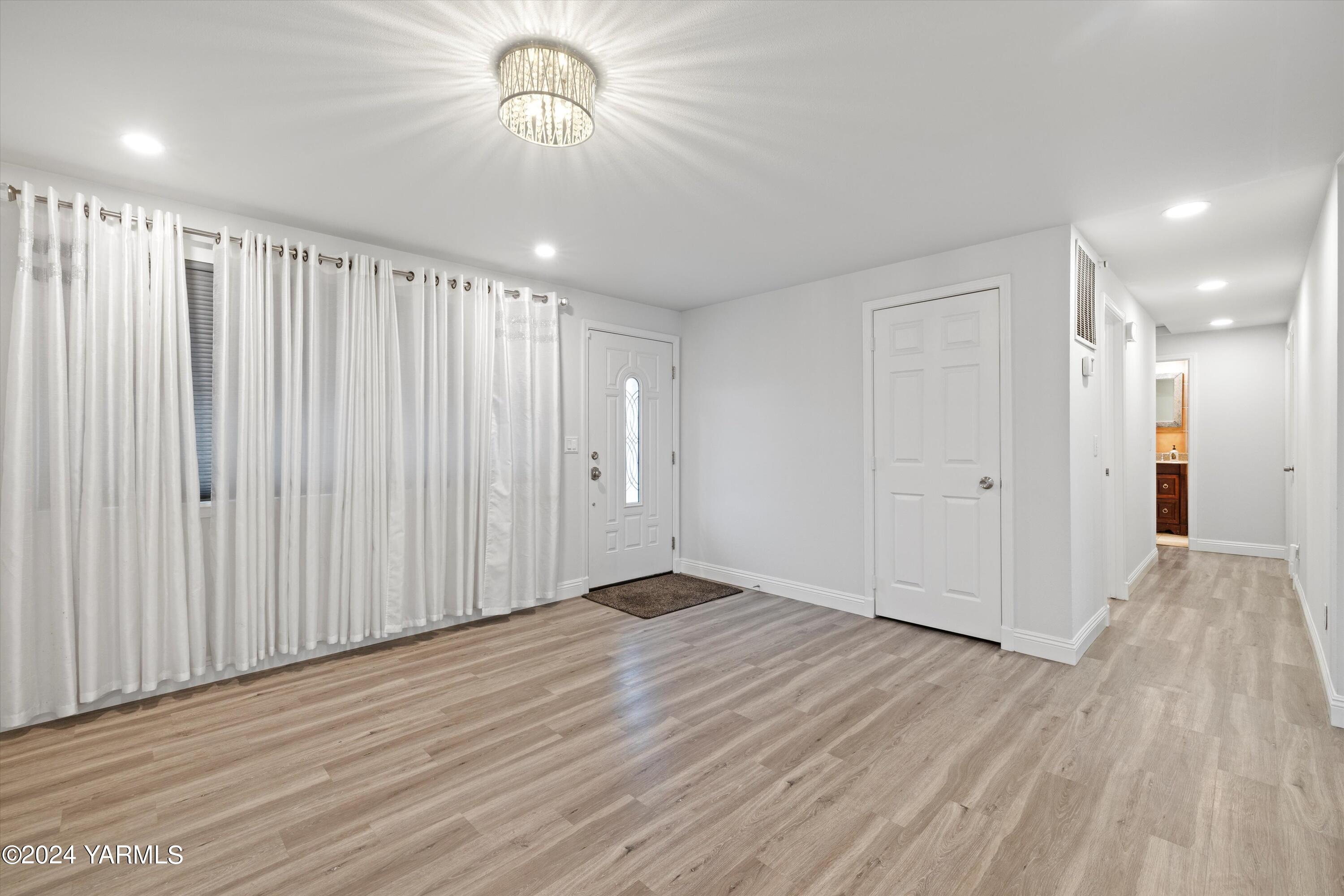 1511 Progressive Road Wapato, WA 98951 - Photo 7 of 36 wooden floor in an empty room with a chandelier