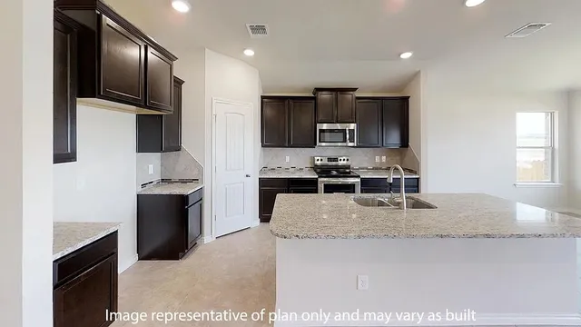 a large kitchen with a large counter top stainless steel appliances and cabinets