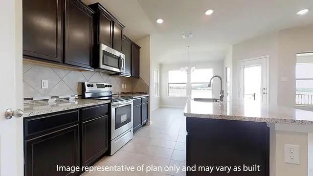 a kitchen with stainless steel appliances granite countertop a stove a sink and a microwave