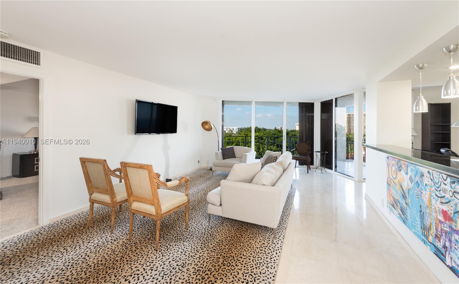 4000 Towerside Terrace, Unit 805 Miami, FL 33138 - Photo 5 of 18 a living room with furniture a flat screen tv and a large window