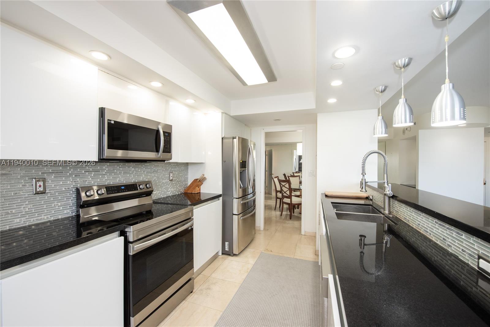4000 Towerside Terrace, Unit 805 Miami, FL 33138 - Photo 7 of 18 a kitchen with granite countertop a stove and a sink