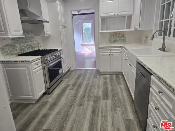 a kitchen with a sink stove top oven and cabinets
