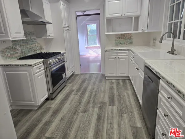 a kitchen with a sink stove top oven and cabinets