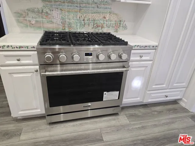 a stove top oven sitting inside of a kitchen