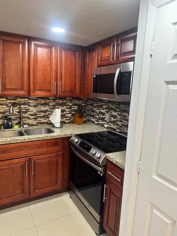 a kitchen with wooden cabinets and a stove top oven