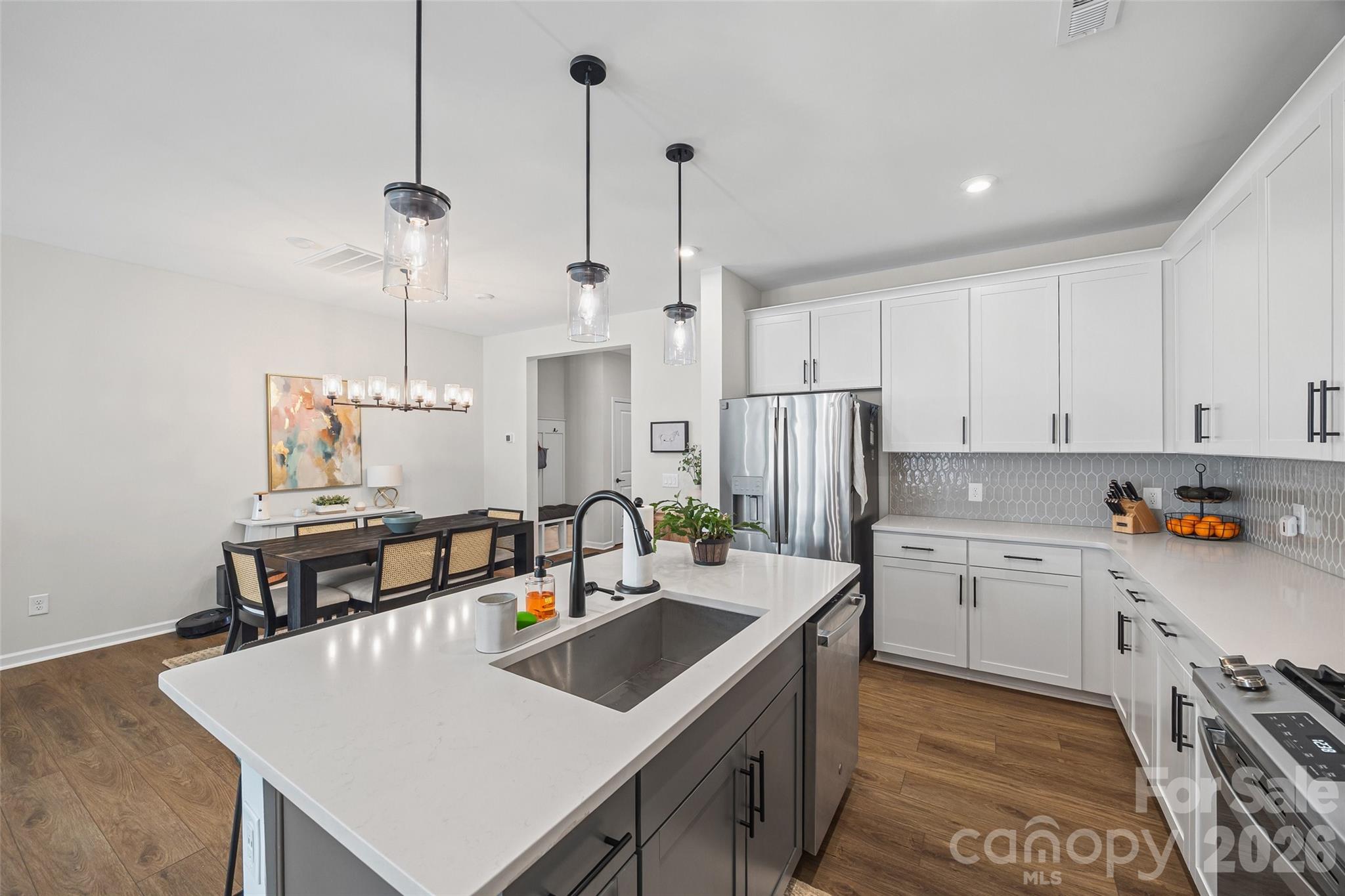 285 Brooks Springs Drive Fort Mill, SC 29708 - Photo 11 of 28 a kitchen with stainless steel appliances a sink a stove a refrigerator and white cabinets with wooden floor