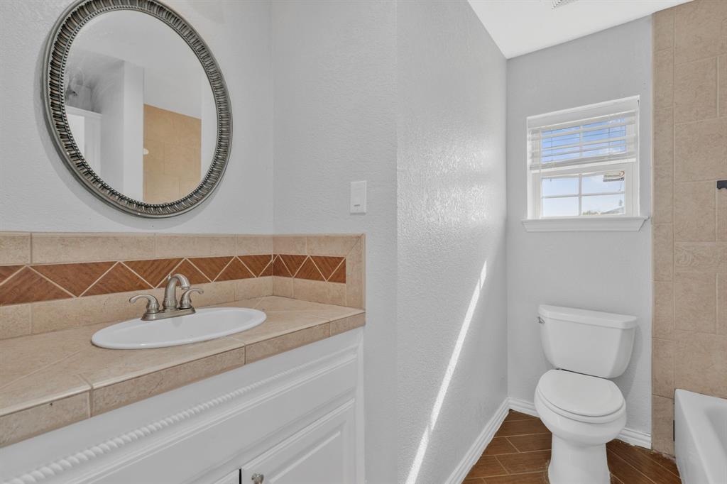 319 Hawk Ridge Decatur, TX 76234 - Photo 17 of 38 a bathroom with a sink a mirror and a toilet