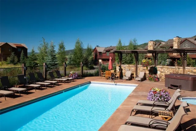a view of a swimming pool with lounge chairs in patio