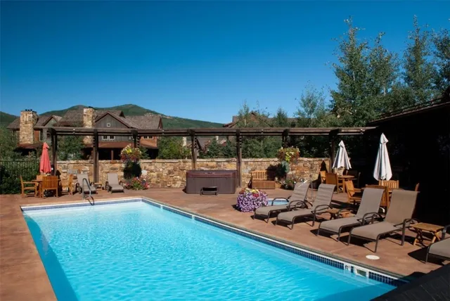 a view of a swimming pool and lounge chairs in patio