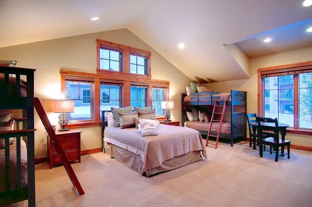a bedroom with a bed a large window and a book shelf