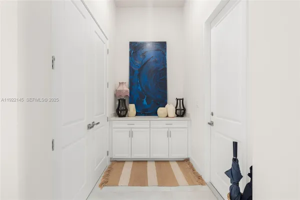 a view of living room with granite countertop lots of white cabinets and white appliances