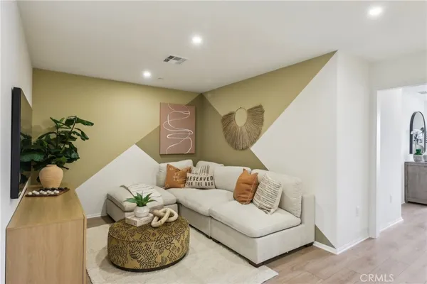 a living room with furniture flowerpot and a chandelier