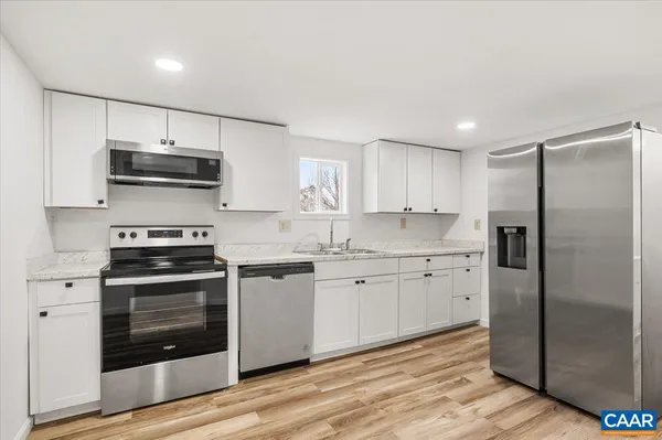 a kitchen with granite countertop a stove a refrigerator and a sink