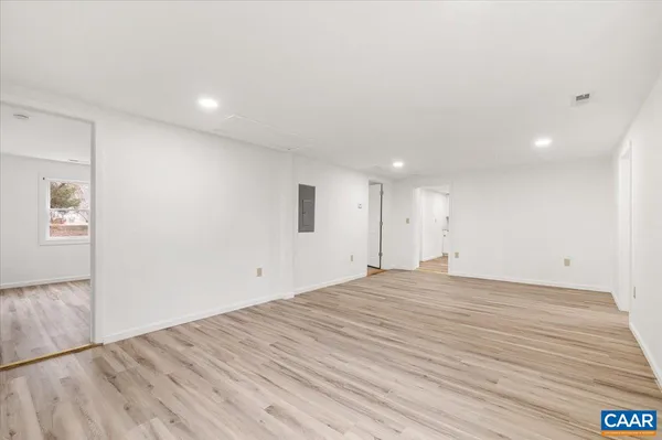 a view of empty room with wooden floor