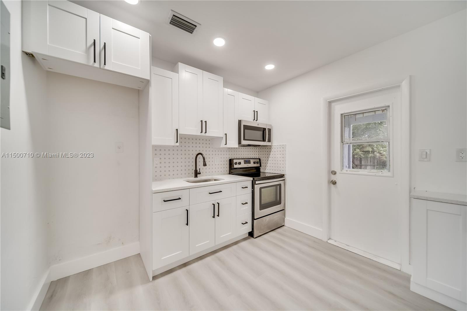 6126 Southwest 19th Street, Unit E Miramar, FL 33023 - Photo 2 of 26 a kitchen with cabinets stainless steel appliances and a window