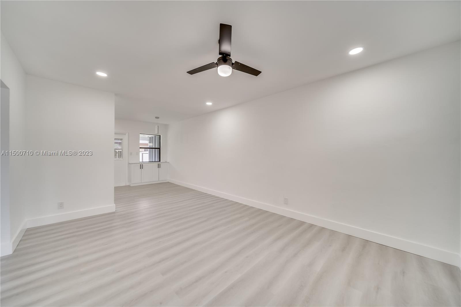 6126 Southwest 19th Street, Unit E Miramar, FL 33023 - Photo 5 of 26 an empty room with wooden floor ceiling fan and windows