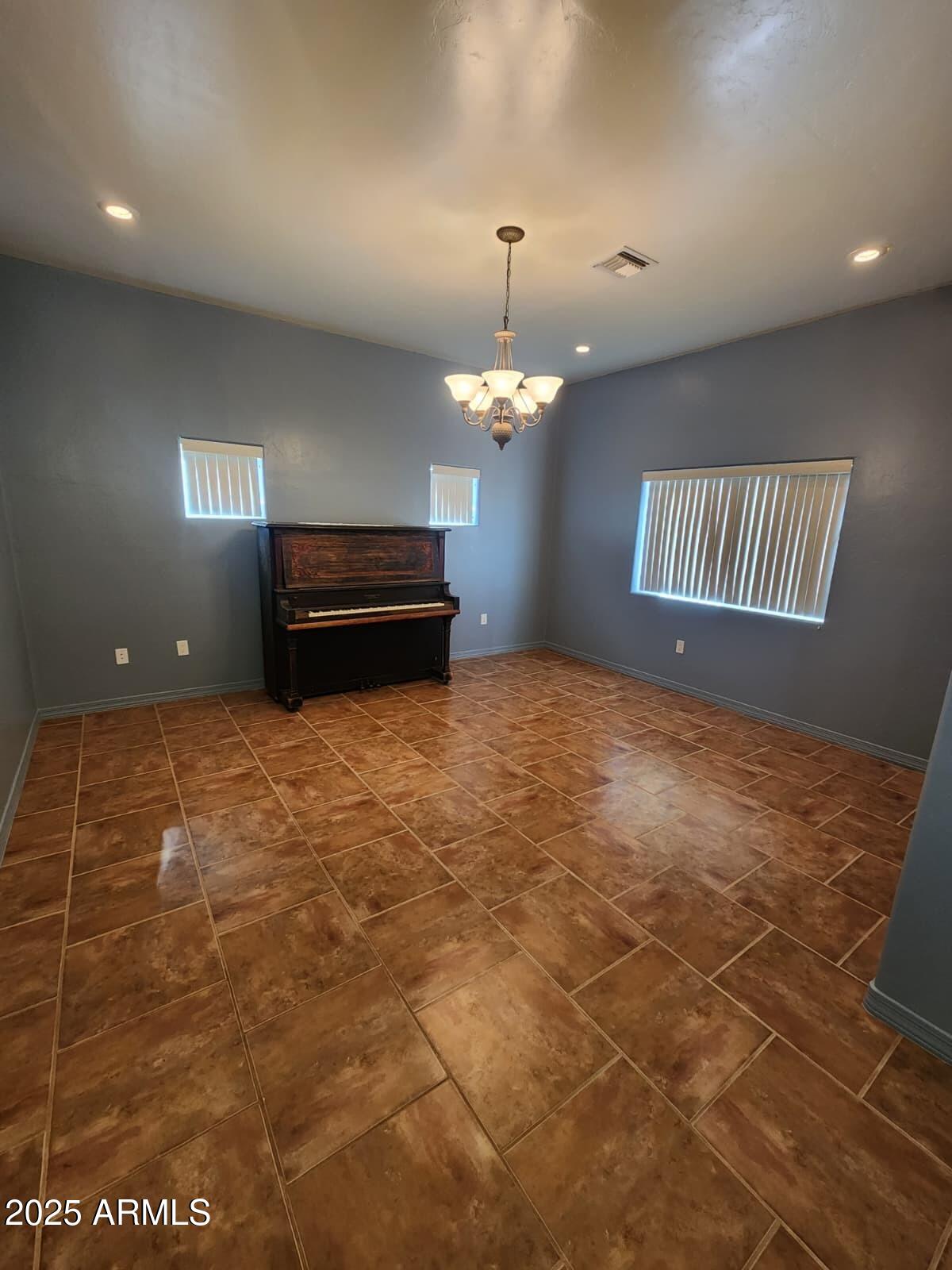 1766 East Golf Course Road Douglas, AZ 85607 - Photo 7 of 29 a room with a chandelier and a rug