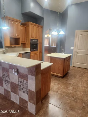 a kitchen with stainless steel appliances granite countertop a refrigerator a stove and a sink