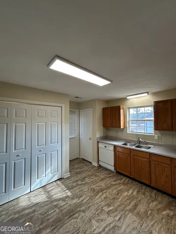 a large kitchen with stainless steel appliances granite countertop a sink and cabinets