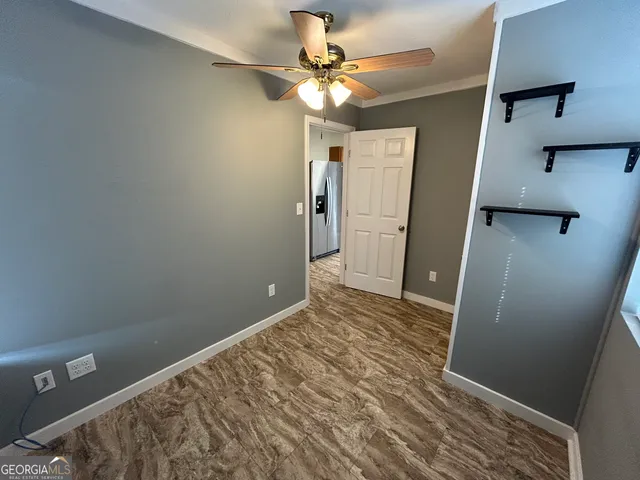 a view of a room with a ceiling fan and a hardwood