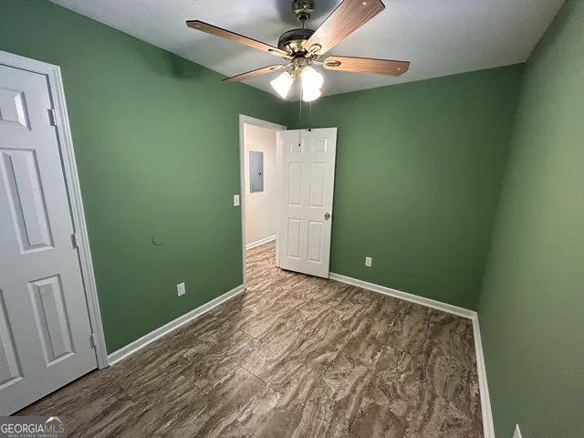 a view of a room with a ceiling fan and a window