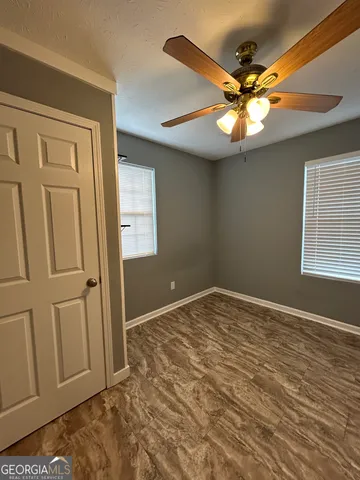a view of a room with wooden floor and a ceiling fan