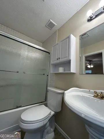 a white toilet sitting next to a shower