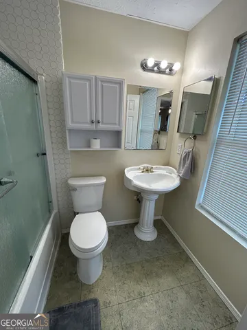 a bathroom with a sink toilet and a mirror