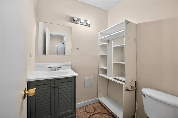a bathroom with a sink toilet and mirror
