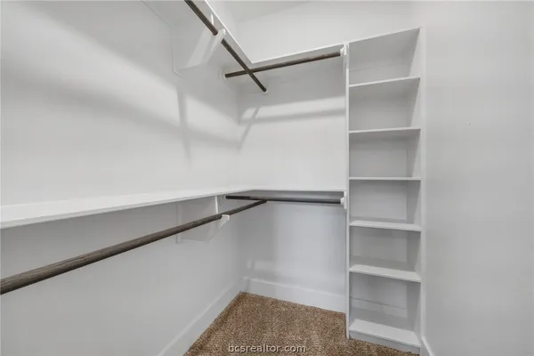 a view of walk in closet with empty racks