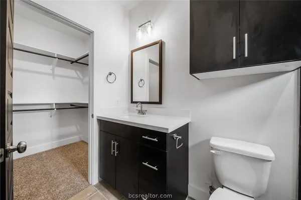 a bathroom with a toilet sink and mirror