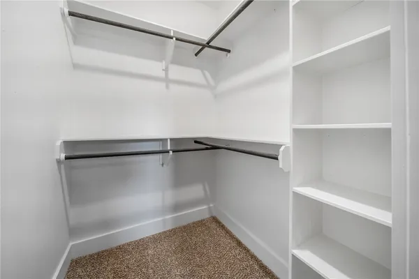 a view of walk in closet with empty racks