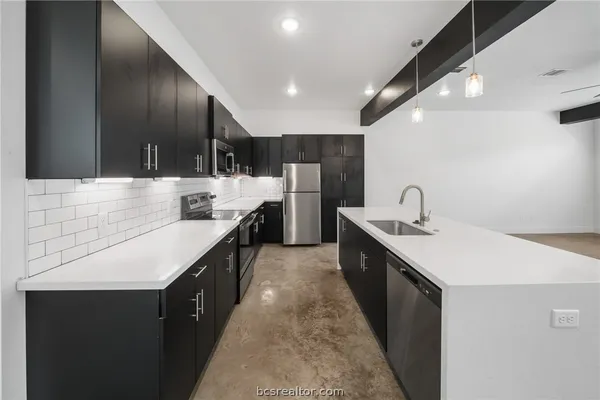 a large kitchen with a sink and cabinets
