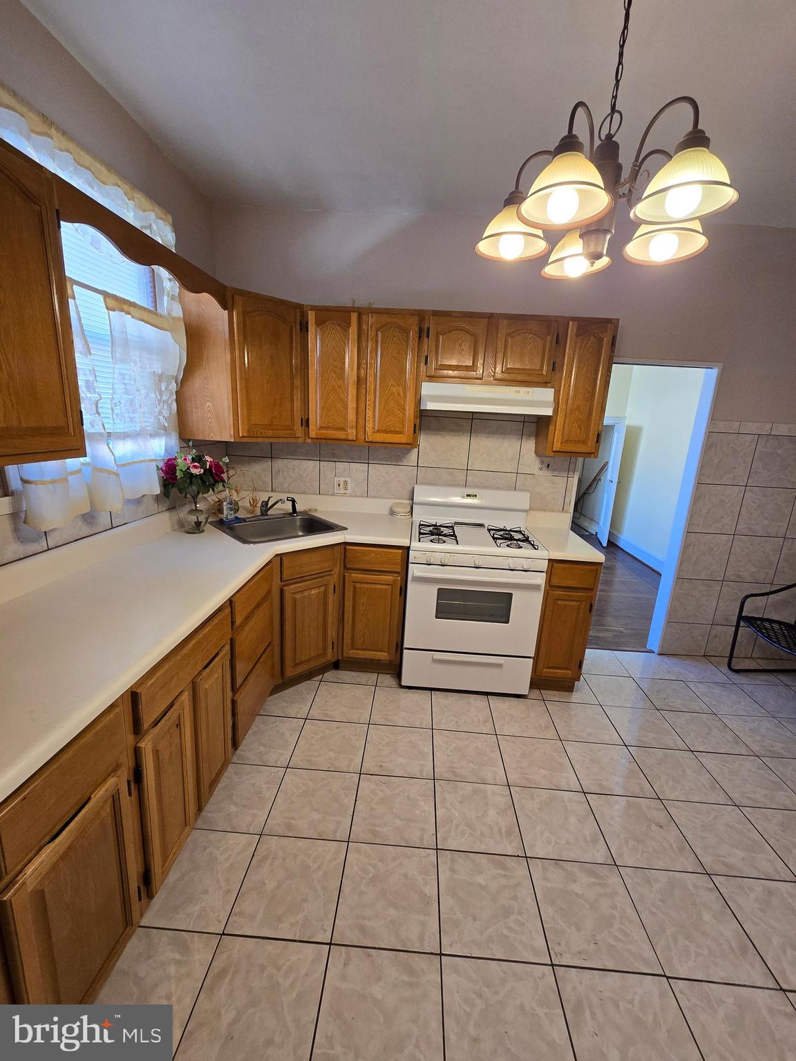 728 South 59th Street Philadelphia, PA 19143 - Photo 14 of 38 a kitchen with a sink a stove cabinets and a counter top space