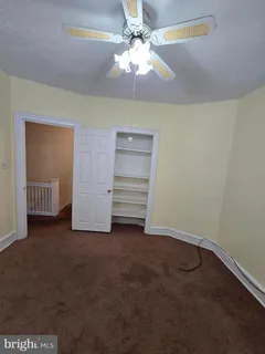 a view of an empty room with a ceiling fan