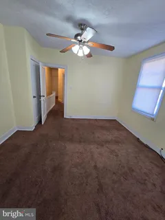 a view of a livingroom with a chandelier fan and a window