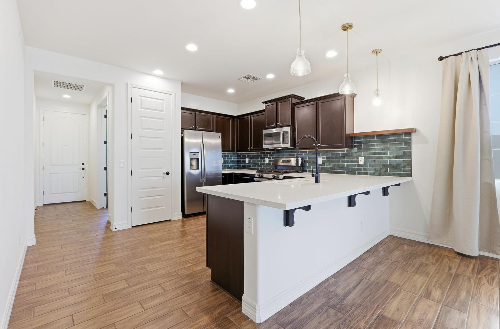 20437 East Estrella Road Queen Creek, AZ 85142 - Photo 8 of 33 a kitchen with kitchen island stainless steel appliances a sink cabinets and wooden floor